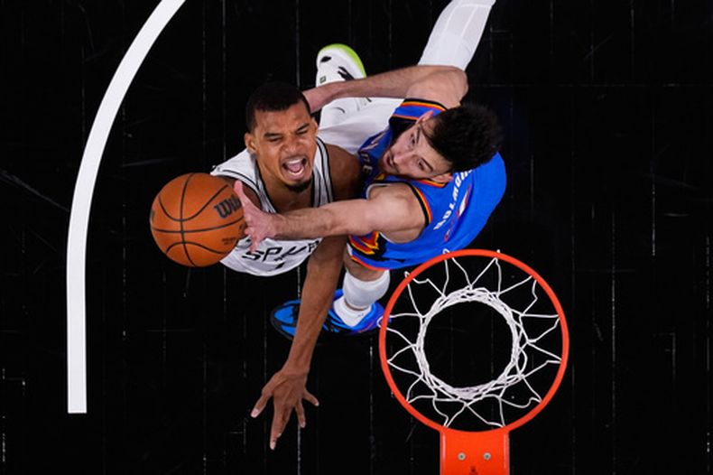 Victor Wembanyama, izquierda, de los Spurs de San Antonio, encesta ante la presión defensiva de Chet Holmgren, derecha, del Thunder de Oklahoma City, en la primera mitad del cuarto juego de las Finales de la Conferencia del Oeste del baloncesto de la NBA, el domingo 24 de mayo de 2026, en San Antonio. (AP Foto/Eric Gay)