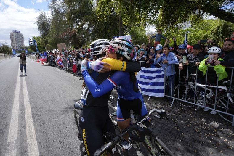 La ecuatoriana Miryam Núnez, izquierda, y la paraguaya Agua Espínola se abrazan luego de cruzar la línea de meta en el ciclismo de ruta para mujeres en los Juegos Panamericanos de Santiago, Chile, el domingo 23 de octubre de 2023. (AP Foto/Fernando Vergara)