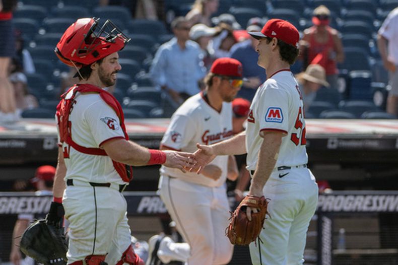 Austin Hedges felicita a su compañero de los Guardianes de Cleveland Matt Festa al final del juego ante los Rangers de Texas el miércoles primero de julio del 2026. (AP Foto/Phil Long)