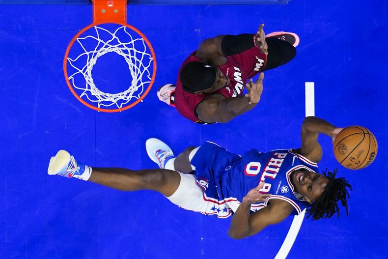 Tyrese Maxey (0), de los 76ers de Filadelfia, se alza para tomar un tiro ante la presión defensiva de Bam Adebayo, del Heat de Miami, durante la primera mitad del juego de baloncesto de la NBA, el lunes 18 de marzo de 2024, en Filadelfia. (AP Foto/Matt Rourke)