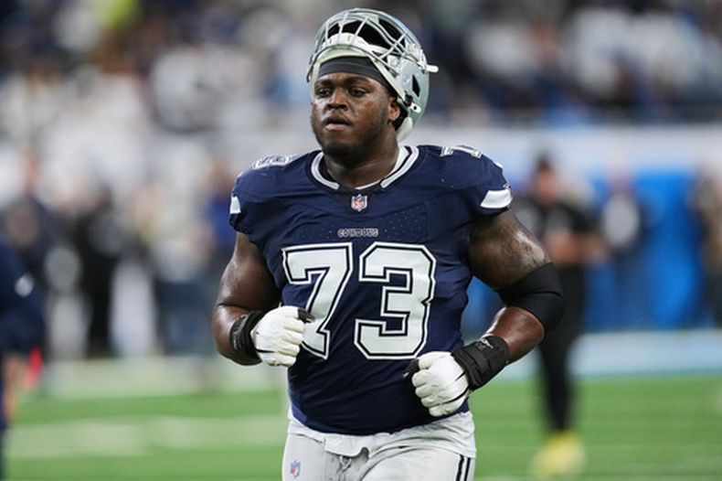 ARCHIVO - Foto del 4 de diciembre del 2025, el tackle ofensivo de los Cowboys de Dallas Tyler Smith calienta en el encuentro ante los Lions de Detroit. (AP Foto/Paul Sancya, Archivo)