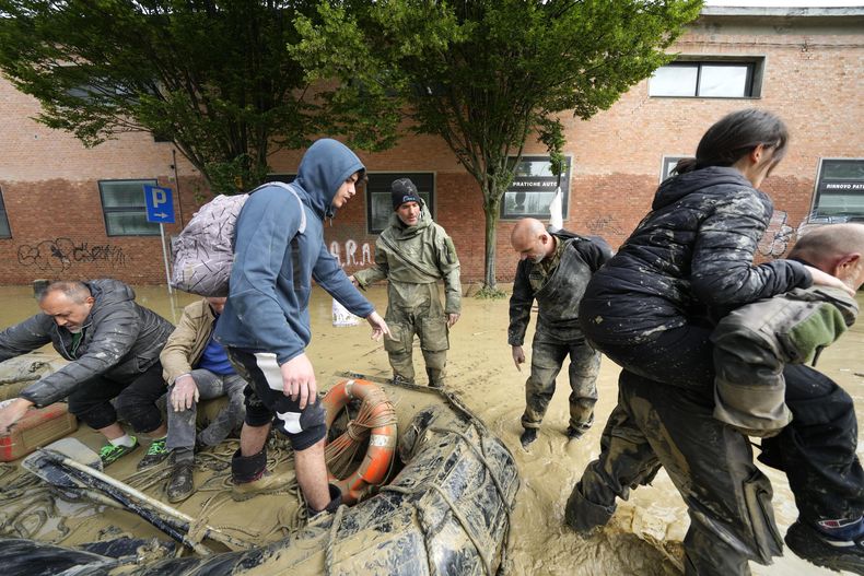 Gente rescatada en Faenza, Italia, el jueves 18 de mayo de 2023. Unas lluvias excepcionales desbordaron ríos y provocaron inundaciones en Italia, donde murieron nueve personas y miles fueron evacuadas. (AP Foto/Luca Bruno)