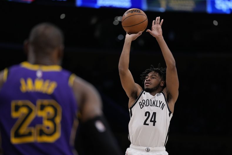 Cam Thomas, base de los Nets de Brooklyn, dispara frente a LeBron James, de los Lakers de Los Ángeles, durante el encuentro del viernes 19 de enero de 2024 (AP Foto/Ashley Landis)