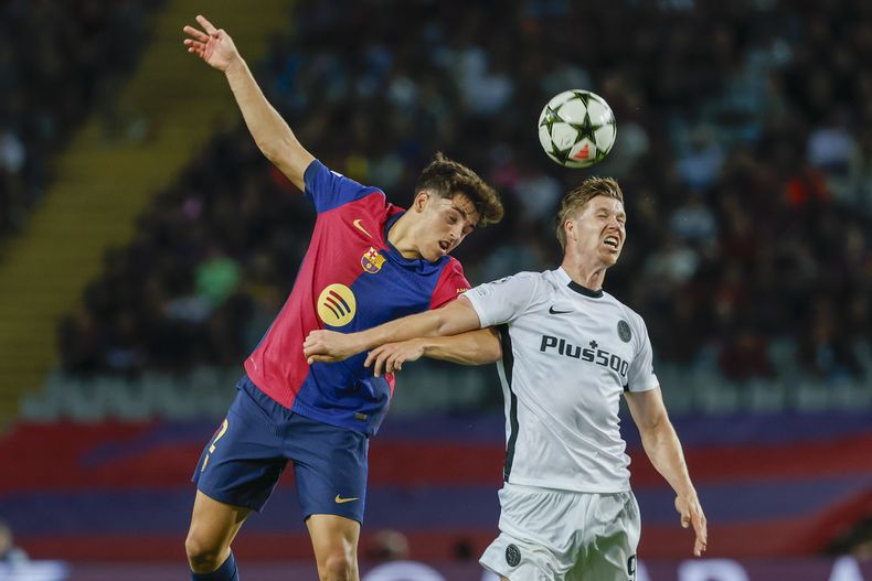 Cedric Itten del Young Boys salta para cabecear el balón junto a Pau Cubarsí en el duelo de Liga de Campeones el martes 1 de octubre del 2024. (AP Foto/Joan Monfort)