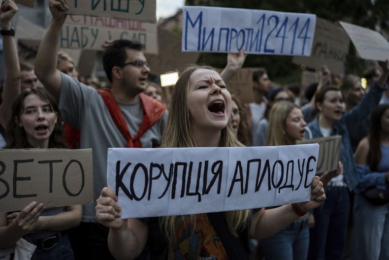 Una mujer grita consignas mientras sostiene un letrero que reza La corrupción aplaude durante una protesta contra una ley que temen socavará la labor de instituciones anticorrupción, el martes 22 de julio de 2025, en Kiev, Ucrania. (AP Foto/Alex Babenko)