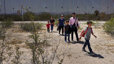 ARCHIVO - Cinco integrantes de una familia que aseguran ser originarios de Guatemala, y un hombre que dice ser de Perú, vestido con camisa rosa, atraviesan el desierto después de cruzar el muro fronterizo, el 29 de agosto de 2023, en el sector Tucson de la frontera entre México y Estados Unidos, en el Monumento Nacional del Cactus de Tubo de Órgano, cerca de Lukeville, Arizona. (AP Foto/Matt York, Archivo)
