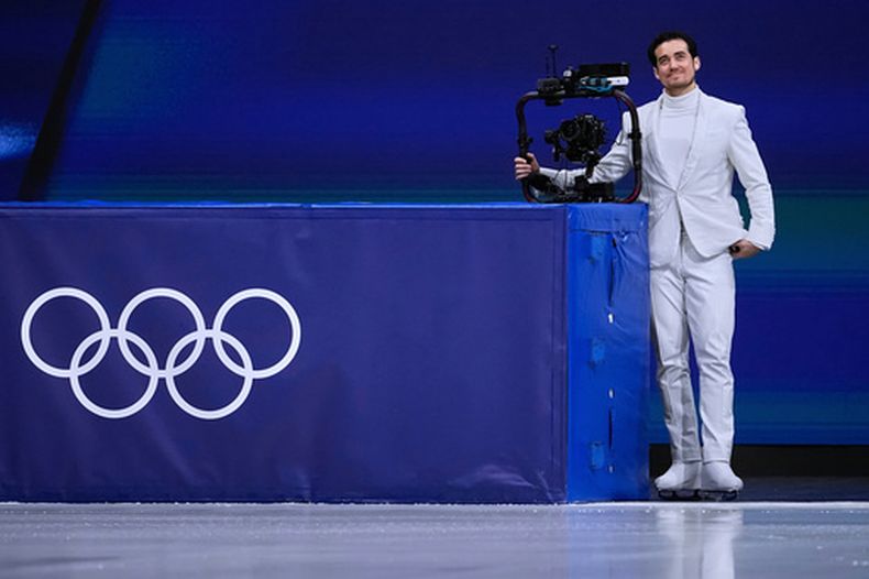 Jordan Cowan opera la cámara antes del programa corto de patinaje artístico por parejas en los Juegos Olímpicos de Invierno de 2026, en Milán, Italia, el domingo 15 de febrero de 2026. (Foto AP/Ashley Landis)