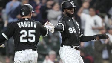 El cubano Luis Robert Jr. festeja con Andrew Vaughn, su compañero de los Medias Blancas de Chicago, durante el encuentro ante los Guardianes de Cleveland, el martes 16 de mayo de 2023 (AP Foto/Charles Rex Arbogast)