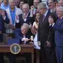 El presidente Donald Trump golpea un mazo que le entregó el presidente de la Cámara de Representantes, Mike Johnson (aplaudiendo en primer plano, a la izquierda), después de que promulgó su ley de recortes fiscales y al gasto público en la Casa Blanca, el viernes 4 de julio de 2025, en Washington. (AP Foto/Evan Vucci)