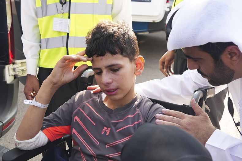 Amr Jandieh, de 12 años, herido en la guerra entre Israel y Hamas, está rodeado de funcionarios emiratíes que lo bajan del avión a una ambulancia en Abu Dabi, Emiratos Árabes Unidos, sábado 18 de noviembre de 2023. (AP Foto/Malak Harb)
