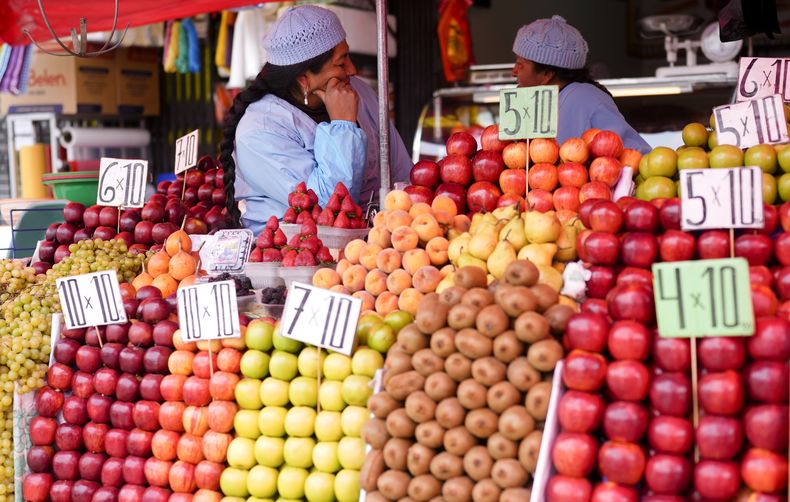 ARCHIVO - Una vendedora de fruta descansa mientras espera que lleguen clientes en un mercado callejero en La Paz, Bolivia, el 27 de noviembre de 2024. (AP Foto/Juan Karita, Archivo)