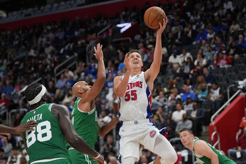 Duncan Robinson, alero de los Pistons de Detroit, dispara frente a Derrick White, de los Celtics de Boston, en el encuentro del martes 20 de octubre de 2026 (AP Foto/Paul Sancya)