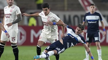 Alfonso Barco, de Universitario de Perú, conduce el balón ante la barrida de Alan Lescano, de Gimnasia y Esgrima de Argentina, en un partido de la Copa Sudamericana, disputado el jueves 28 de junio de 2023 (AP Foto/Martín Mejía)