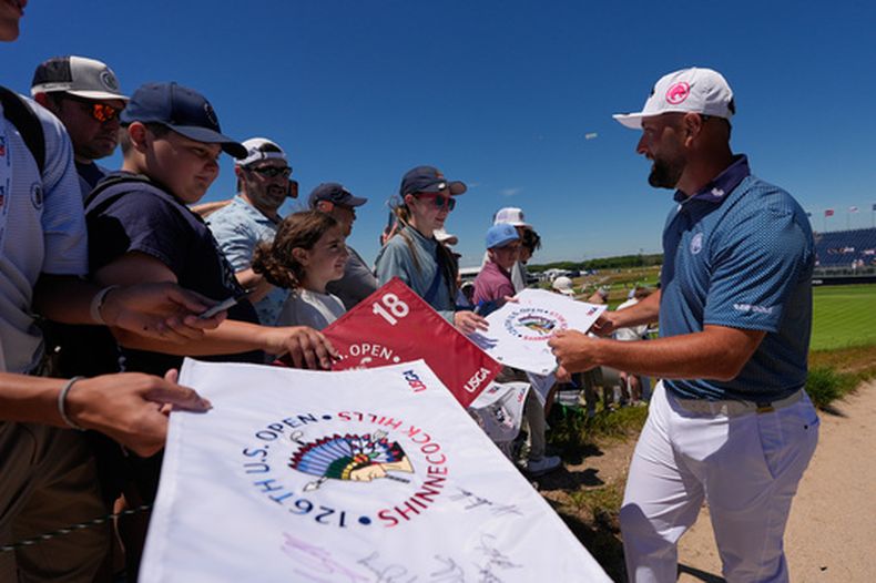 El español Jon Rahm firma autógrafos durante una ronda de práctica del Abierto de Estados Unidos de Golf, en el campo del Club de Golf Shinnecock Hills, el lunes 15 de junio de 2026, en Southampton, Nueva York. (AP Foto/David J. Phillip)