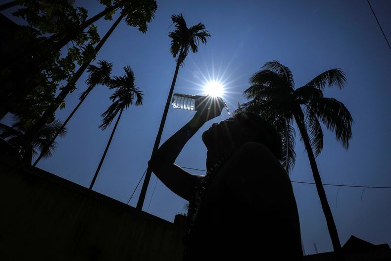 Una persona trata de protegerse del calor echándose agua en la cara en Guwahati, India, el 25 de mayo del 2024.. (Foto AP/Anupam Nath)