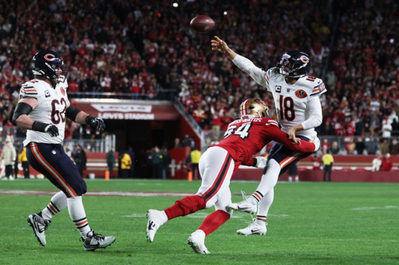 Caleb Williams (18), el mariscal de campo de los Bears de Chicago, lanza el balón bajo la presión de el estadounidense Yetur Gross-Matos (94), ala defensiva de los 49ers de San Francisco, en la jugada final de la segunda mitad de un juego de fútbol americano de la NFL en Santa Clara, California, el domingo 28 de diciembre de 2025. (AP Photo/Jed Jacobsohn)