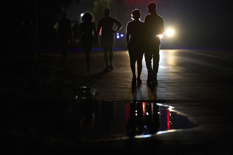La gente camina en la oscuridad durante un apagón parcial en La Habana, Cuba, el miércoles 28 de mayo de 2025. (AP Foto/Ramón Espinosa)