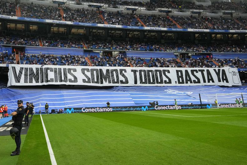 Espectadores despliegan la pancarta con la frase Vinicius Somos Todos, Basta Ya en el estadio Santiago Bernabéu durante el partido entre el Real Madrid y el Rayo Vallecano por la Liga de España, el miércoles 24 de mayo de 2023. (AP Foto/Manu Fernández)