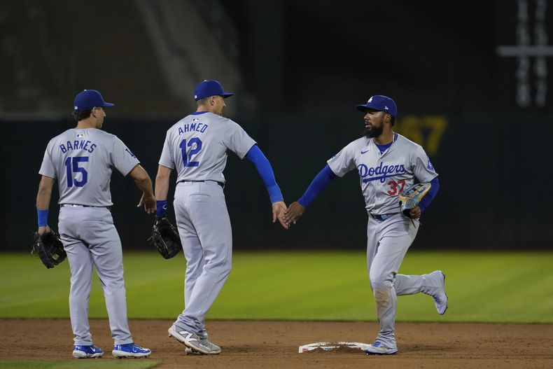 El jardinero izquierdo de los Dodgers de Los Ángeles, Teoscar Hernández, a la derecha, celebra con el campocorto Nick Ahmed (12) después de su victoria sobre los Atléticos de Oakland el sábado 3 de agosto de 2024 en Oakland, California (AP Foto/Godofredo A. Vásquez)