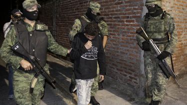 americateve | ARCHIVO - La foto del 3 de diciembre de 2010 muestra a soldados mexicanos que custodian a Edgar, conocido como  "El Ponchis" y el "ni&ntilde;o sicario", quien confeso haber perpetrado asesinatos  para el cartel de los hermanos Beltr&aa