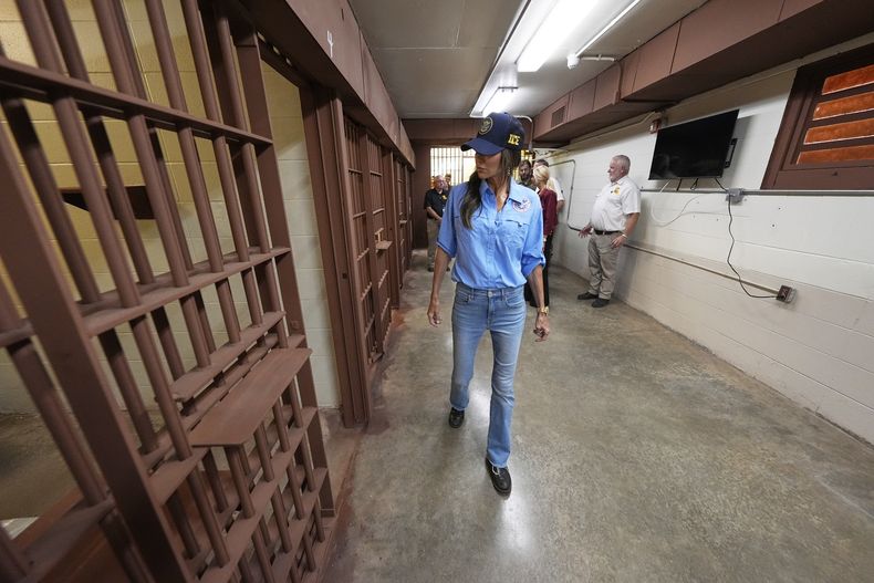 La secretaria de Seguridad Nacional, Kristi Noem (centro), recorre Camp 57, un centro para albergar migrantes detenidos en la Penitenciaría Estatal de Luisiana, en Angola, Luisiana, el 3 de septiembre de 2025. (AP Foto/Gerald Herbert, Pool)