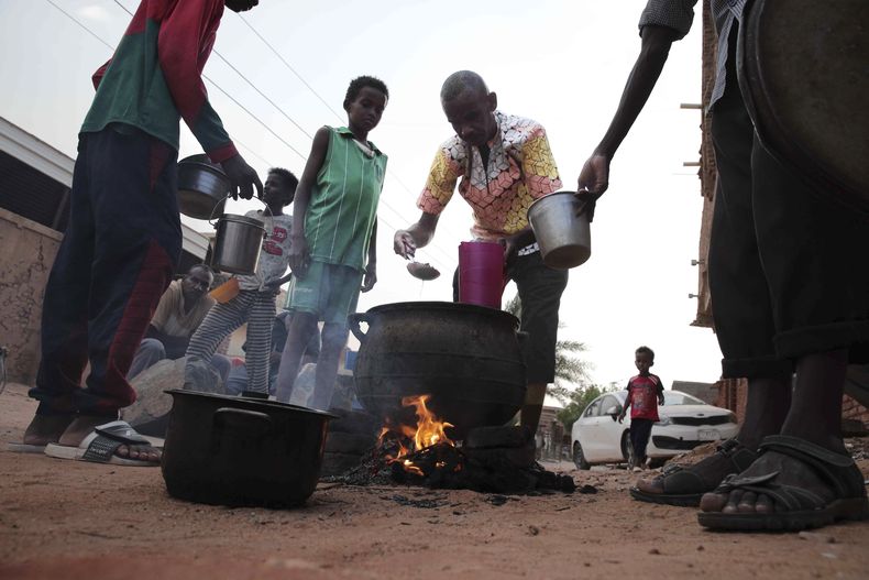 Varias personas cocinan el 16 de junio de 2023 en un barrio de Jartum, Sudán. (AP Foto)