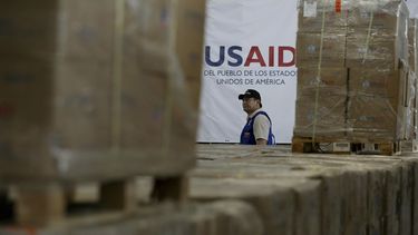 Un hombre pasa frente a cajas de ayuda humanitaria de USAID en un almacén en las afueras de Cúcuta, Colombia, el 21 de febrero de 2019, en la frontera con Venezuela. (AP Foto/Fernando Vergara)