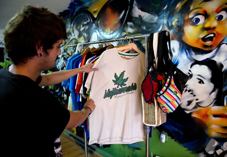 Un cliente observa una camiseta decorada con una hoja de marihuana y la palabra "Mujicannabis" en una tienda de Montevideo, Uruguay, martes 6 de mayo de 2014. El presidente Jos&eacute; Mujica firm&oacute; en la fecha la ley de reglamentaci&oacut