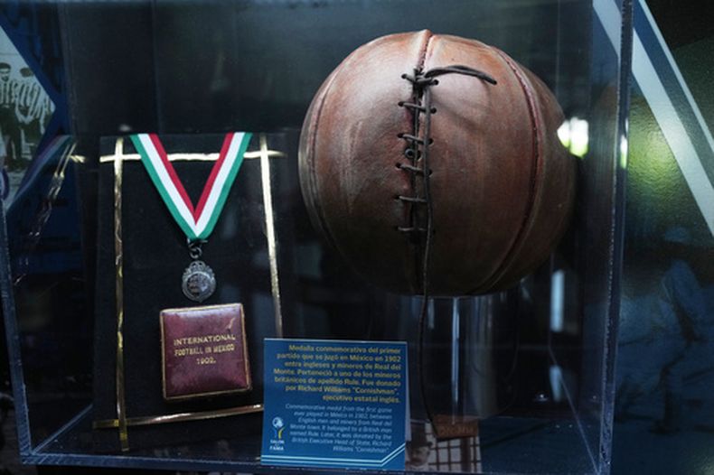 Un balón de fútbol y una medalla de 1902 se exhiben en el Salón de la Fama del Futbol Internacional en Pachuca, estado de Hidalgo, México, el jueves 14 de mayo de 2026. (Foto AP/Marco Ugarte)