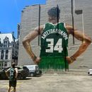 Danny Nelson luce una camiseta de los Bucks de Milwaukee de Giannis Antetokounmpo mientras contempla un mural suyo en el centro de Milwaukee el martes 23 de junio de 2026. (Foto AP/Steve Megargee)