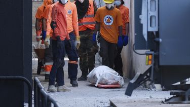 Rescatistas, junto al cadáver recuperado de una persona que falleció por el derrumbe del techo de la discoteca Jet Set durante un concierto de merengue dos noches antes, en Santo Domingo, República Dominicana, el 9 de abril de 2025, (AP Foto/Ricardo Hernández)
