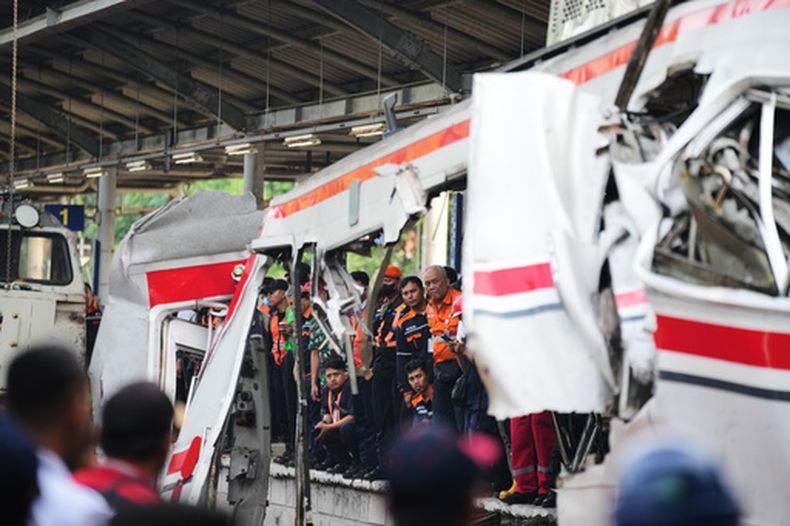 Trabajadores y equipos de rescate examinan los restos de un choque de trenes en Bekasi, Indonesia, el martes 28 de abril de 2026. (AP Foto/Tatan Syuflana)