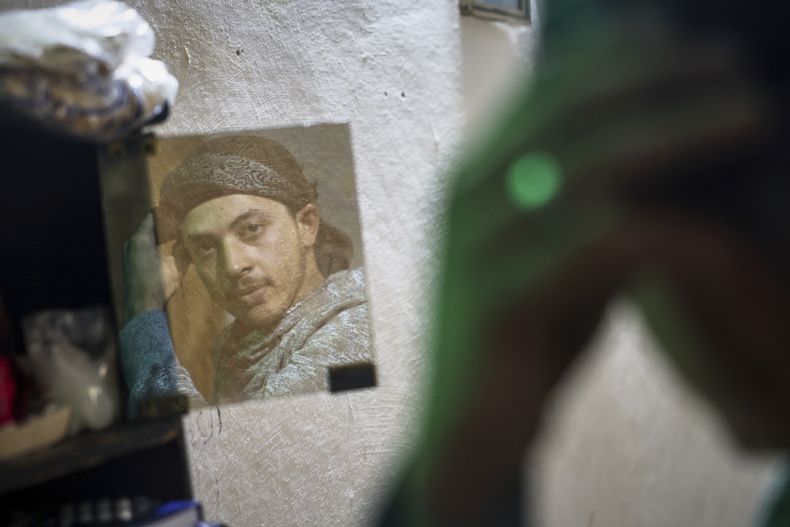 Suleiman Jalil, un joven de 21 años que perdió una pierna debido a la explosión de una mina terrestre mientras cosechaba aceitunas con sus amigos en un campo, se refleja en un espejo en su casa en el poblado de Qaminas, el miércoles 9 de abril de 2025, en Idlib, Siria. (AP Foto/Ghaith Alsayed)