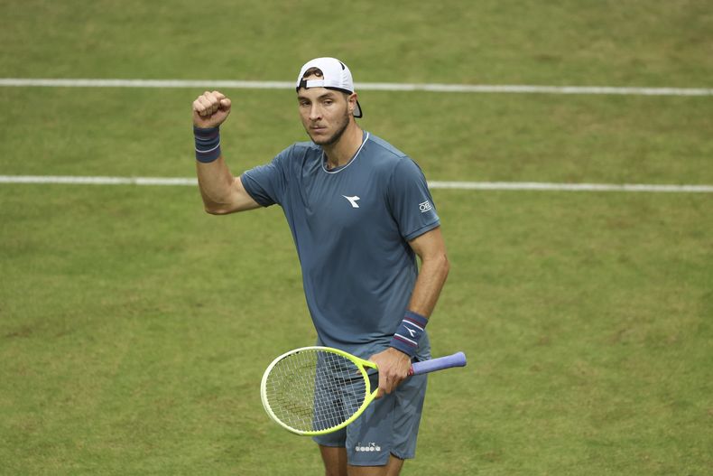 El local Jan-Lennard Stuff festeja su victoria sobre el griego Stefanos Tsitsipas en el torneo de Halle, Alemania, el jueves 20 de junio de 2024 (Friso Gentsch/dpa via AP)