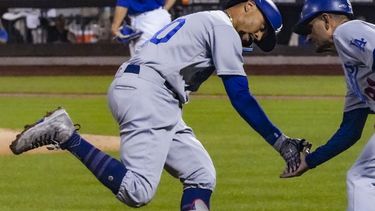 Mookie Betts, de los Dodgers de Los Ángeles, festeja con el coach de tercera Dino Ebel, luego de conectar un jonrón en el juego del sábado 15 de julio de 2023, ante los Mets de Nueva York (AP Foto/Bebeto Matthews)