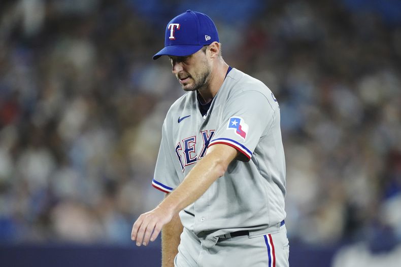 El abridor de los Rangers de Texas estira el brazo tras salir del juego contra los Azulejos de Toronto, el martes 12 de septiembre de 2023, en Toronto. (Nathan Denette/The Canadian Press vía AP)
