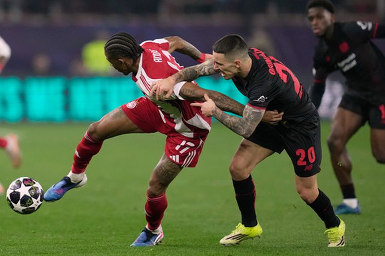 ARCHIVO - Foto del 18 de febrero del 2026, Alex Grimaldo del Bayer Leverkusen pelea por el balón en un encuentro de la Liga de Campeones ante Andre Luiz del Olympiacos. (AP Foto/Thanassis Stavrakis, Archivo)
