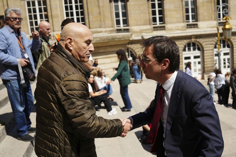 Yunice Abbas, a la izquierda, uno de los hombres acusados del robo a mano armada contra Kim Kardashian en 2016, estrecha la mano de su abogado Gabriel Dumenil afuera del palacio de justicia el lunes 28 de abril de 2025 en París. (Foto AP/Aurelien Morissard)