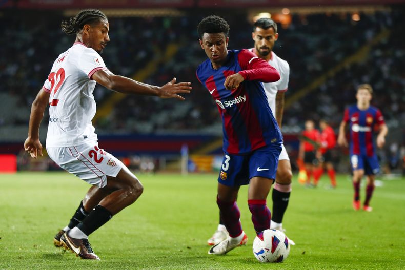 Alejandro Balde, del Barcelona, a la derecha, disputa el balón con Loic Bade, del Sevilla, durante el partido del viernes 29 de septiembre de 2023, en Barcelona. (AP Foto/Joan Monfort)