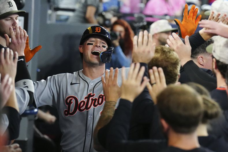 Spencer Torkelson (20), de los Tigres de Detroit, es recibido en el dugout por sus compañeros de equipo después de conectar un jonrón solitario durante la segunda entrada de una pelota de béisbol contra los Azulejos de Toronto en Toronto, el sábado 17 de mayo de 2025. (Chris Young/The Canadian Press vía AP)