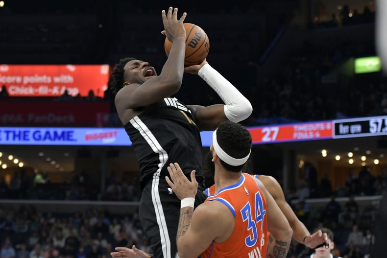 El alero de los Grizzlies de Memphis, Jaren Jackson Jr., dispara contra el alero del Thunder de Oklahoma City, Kenrich Williams, en la primera mitad de un partido de baloncesto de la NBA, el sábado 16 de marzo de 2024, en Memphis, Tennessee. (AP Foto/Brandon Dill)
