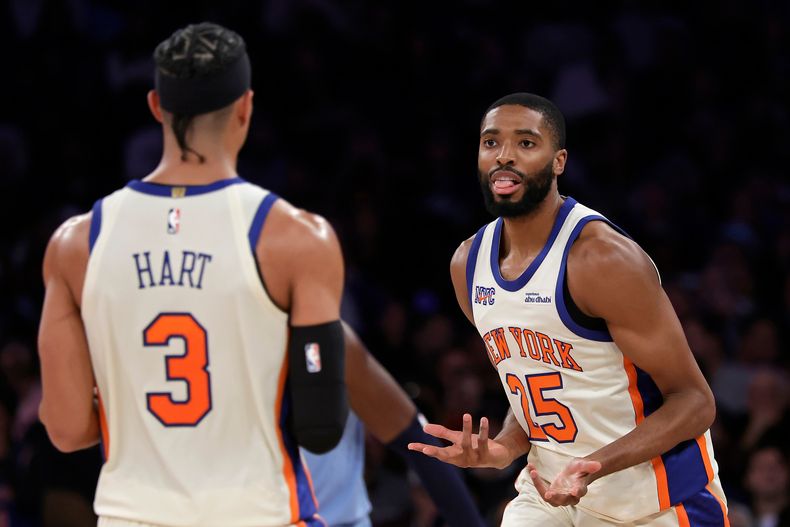 Mikal Bridges, de los Knicks de Nueva York, festeja con su compañero Josh Hart tras atinar un disparo en el encuentro del martes 11 de noviembre de 2025, ante los Grizzlies de Memphis (AP Foto/Adam Hunger)