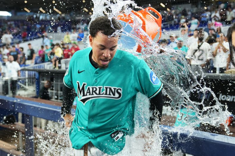 Heriberto Hernández, de los Marlins de Miami, es bañado tras conectar un grand slam para dejar en el terreno al rival durante la novena entrada, derrotando a los Mets de Nueva York en un partido de béisbol, el domingo 24 de mayo de 2026, en Miami. (Foto AP/Lynne Sladky)