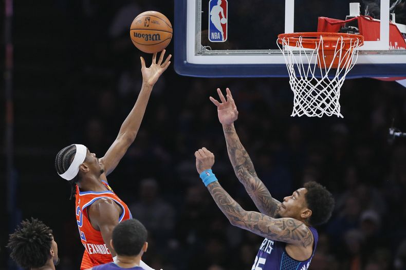 Shai Gilgeous-Alexander, del Thunder de Oklahoma City, dispara frente a P.J. Washington, en el encuentro del viernes 2 de febrero de 2024 (AP Foto/Nate Billings)