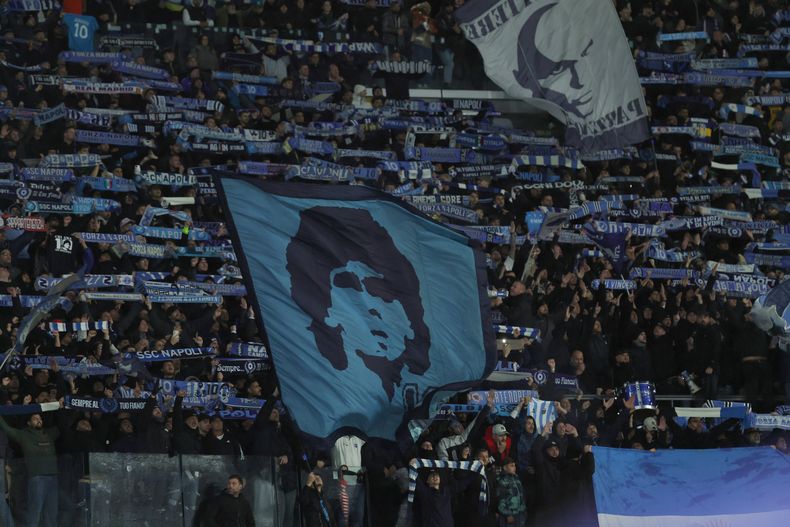 Seguidores del Napoli muestran una bandera con la semblanza de Diego Maradona en el aniversario de su fallecimiento antes del duelo ante Qarabag el martes 25 de noviembre del 2025. (Alessandro Garofalo/LaPresse via AP)