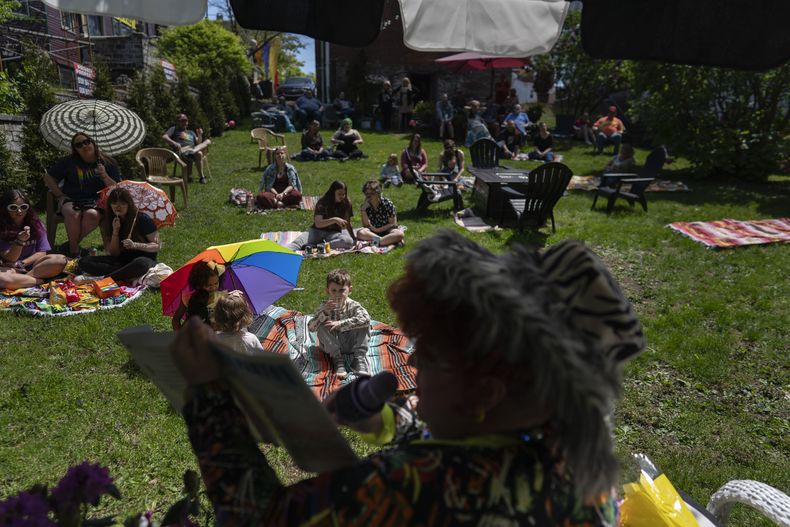 La drag queen Alexus Daniels lee Coat of Many Colors de Dolly Parton a niños, familiares y amigos en la actidad Drag Storytime! en Mt. Carmel, Pensilvania, en el jardín de Pink Moon Collective, el 6 de mayo de 2023. (Foto AP/Carolyn Kaster)