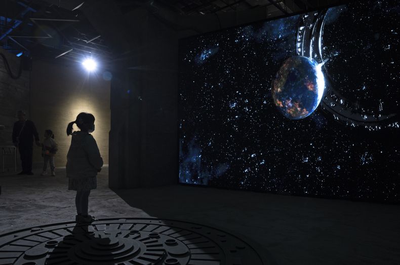 Una niña mira un vídeo que representa el universo de ciencia ficción de una trilogía del autor chino Liu Cixin en Chengdu, provincia de Sichuan, el sábado 21 de octubre de 2023. La serie que comenzó con El problema de los tres cuerpos ayudó a la ciencia ficción china a abrirse paso a nivel internacional, ganando premios y llegando a las listas de lectura de personas como el ex presidente estadounidense Barack Obama y Mark Zuckerberg. (Foto AP/Ng Han Guan)