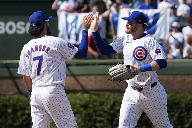El campocorto de los Cachorros de Chicago, Dansby Swanson, a la izquierda, celebra con Ian Happ después de que los Cachorros derrotaron 8-2 a los Mellizos de Minnesota en Chicago, el miércoles 7 de agosto de 2024. (AP Foto/Nam Y. Huh)