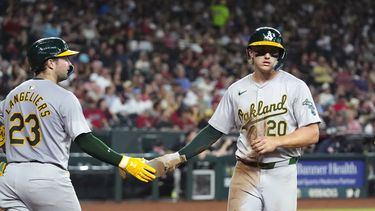 Zack Gelof, de los Atléticos de Oakland, festeja con su compañero Shea Langeliers tras anotar ante los Diamondbacks de Arizona en el encuentro del viernes 28 de junio de 2024 (AP Foto/Ross D. Franklin)
