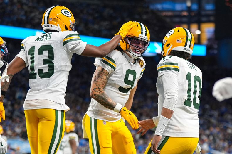El receptor de los Packers de Green Bay Christian Watson celebra su touchdown con el receptor Dontayvion Wicks y el quarterback Jordan Love en el juego ante los Lions de Detroit el jueves 27 de noviembre del 2025. (AP Foto/Ryan Sun)